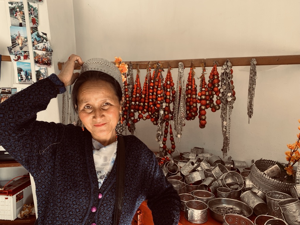 A Khasi woman smiling before her artifacts. Meghalaya