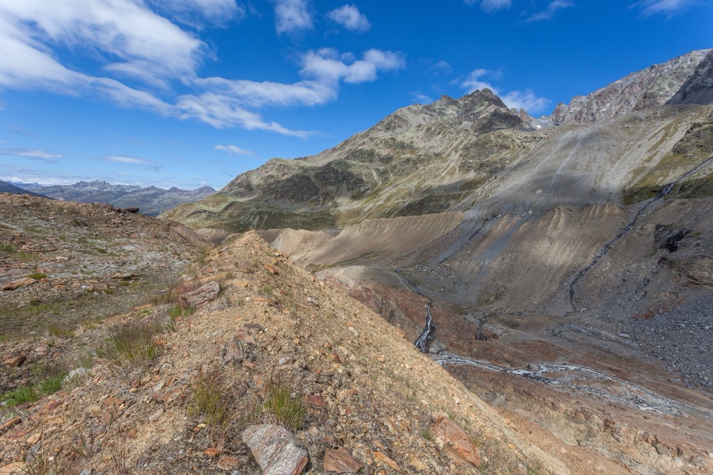 The towering moraines on the valley walls exhibit the most recent historical terminus of the Vallelunga Glacier, approximately 150 years ago. Saldurkamm