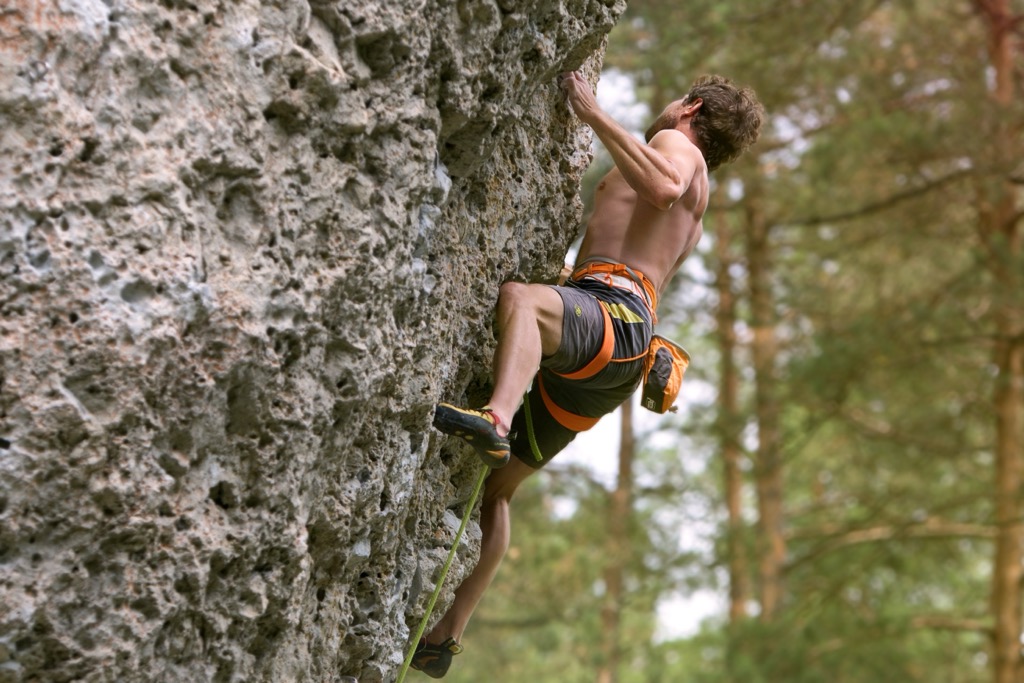 A sport climber on the steep, pocketed limestone of the Frankenjura, Germany