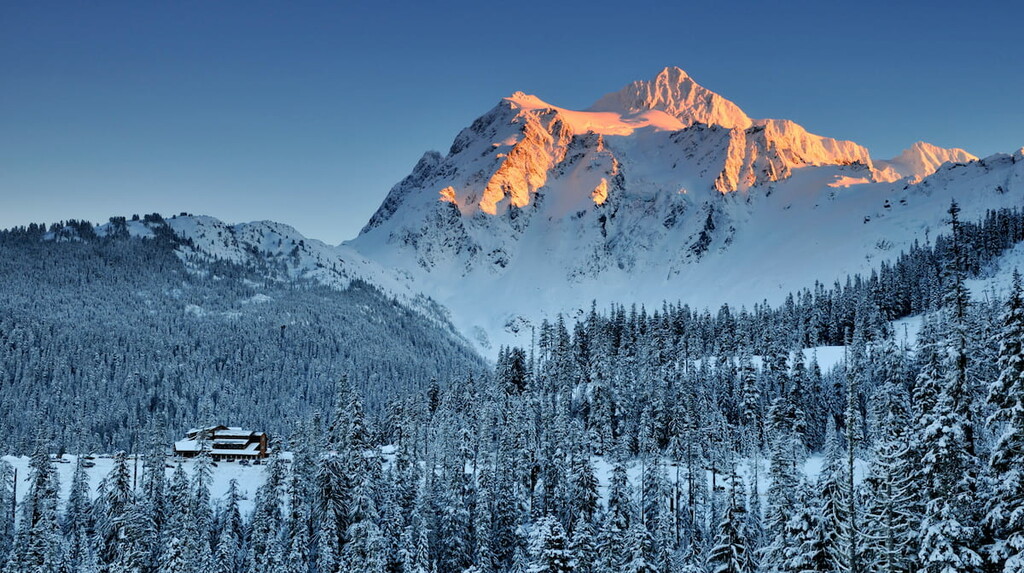 Mount Shuksan winter sunset with ski lodge at the foot of the mountain