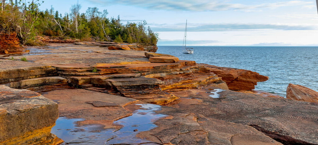 Sailboat parked along the rocky shoreline of the Devils Island in the Apostle Islands