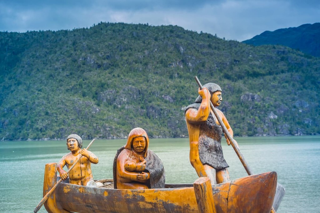 Traditional public wood carvings depicting locals by the walkways of the village of Caleta Tortel