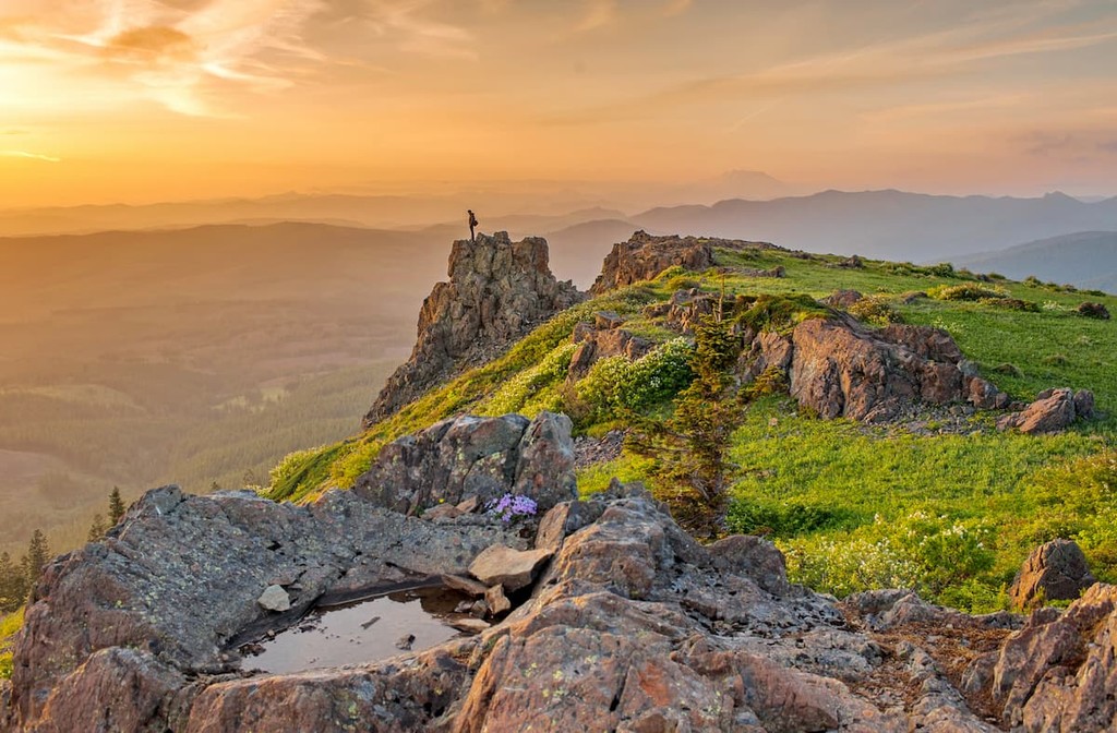 Hiker standing in mountain cliff during sunset in Washington State. Skamania County